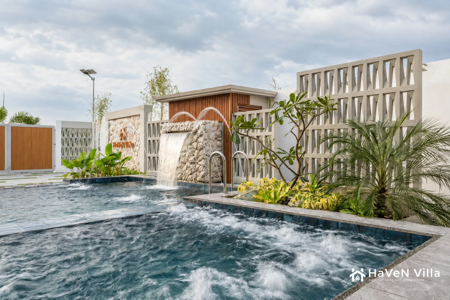 Pool water feature with fountain jets, a stone cascade, breeze blocks, and tropical plants