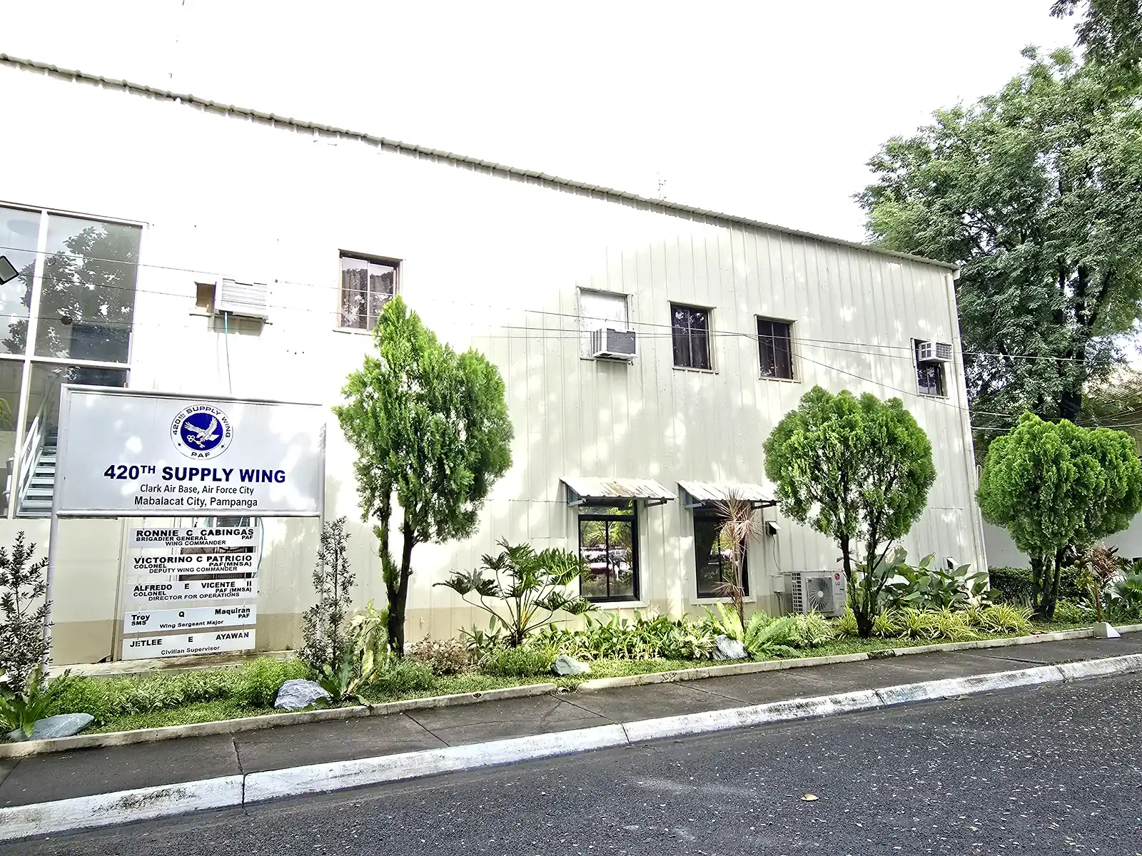 420th Supply Wing building with trimmed trees and planting along the roadside
